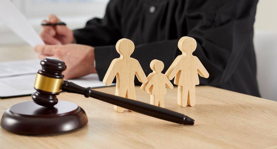 Judge's gavel and wooden family figures on a desk