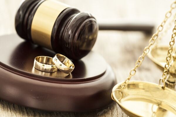 Gavel, two wedding rings, and the scales of justice